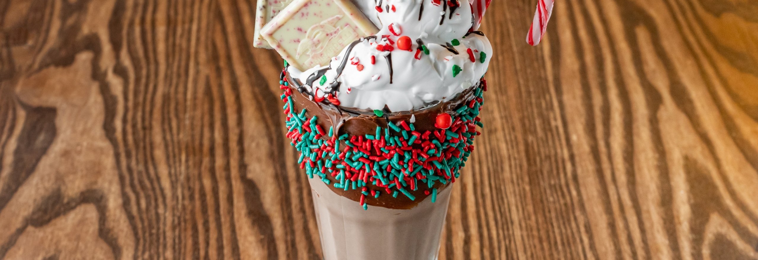 Chocolate milkshake with whipped cream, white chocolate and sprinkles, celebrating the Holidays